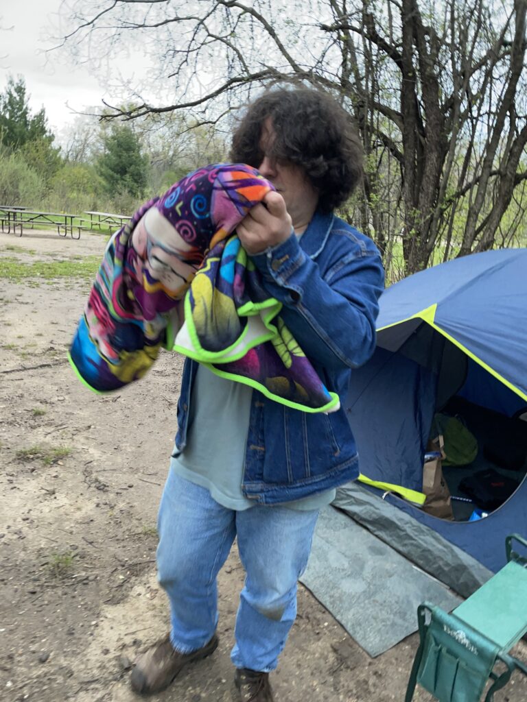 Photograph of Itico's author with a borrowed blanket outside his tent.